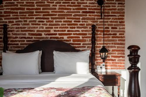 a bedroom with a bed with a brick wall at Soy Local Insignia in Cartagena de Indias