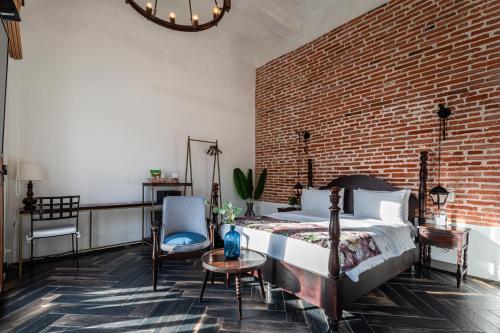a bedroom with a bed and a brick wall at Soy Local Insignia in Cartagena de Indias