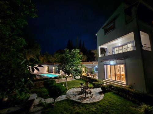 a house with a patio and a swimming pool at night at Ionian Juliet Villas in Kothoníkion