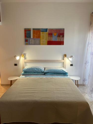 a bedroom with a bed with a painting on the wall at Attico con terrazza in Via dei Traghetti in Lido di Ostia