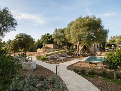 a garden with a swimming pool and trees at Fincahotel Treurer - Olive Grove & Grand House - Adults Only in Algaida
