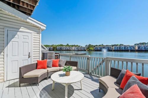 a deck with chairs and a table and a view of the water at ☆Live on the Water! Lake Palmetto Palm w/ Patio - 10Min to Downtown & Beaches☆ in Charleston