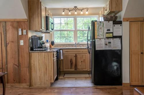 a kitchen with a black refrigerator and a window at Mockingbird Mountain Spa and Retreat in Luray