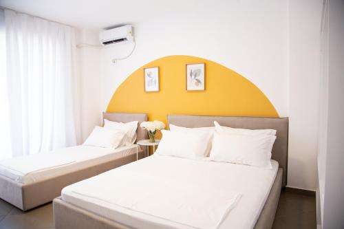2 camas en una habitación de hotel con cabecero amarillo en Lulu Suites - Sunflower, en Golem