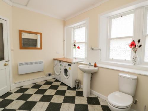 La salle de bains est pourvue d'un lavabo et d'un lave-linge. dans l'établissement Apartment 2, à Stirling