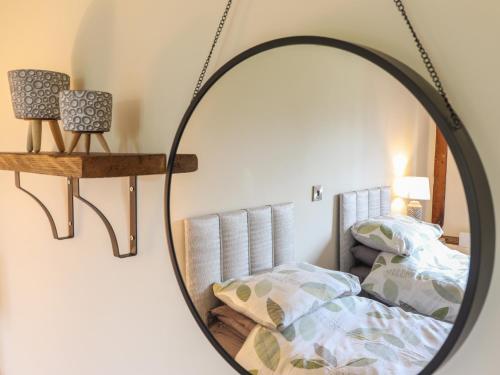 a mirror in a bedroom with a bed at Ysgubor Fachwen in Newtown
