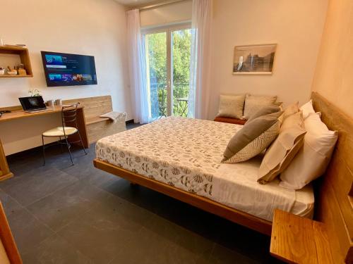 a bedroom with a bed and a desk and a window at Monterosso Rooms in Monterosso al Mare
