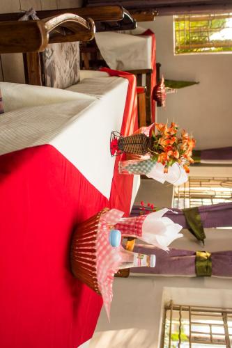 una habitación con 2 camas y un jarrón con flores en Scroll Inn Hotel en Kampala