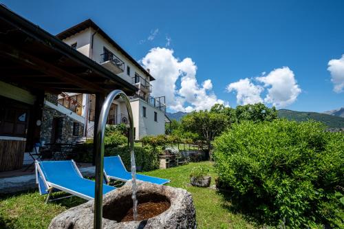 a couple of blue chairs sitting in a yard at Agribenessere Brenzio in Consiglio di Rumo