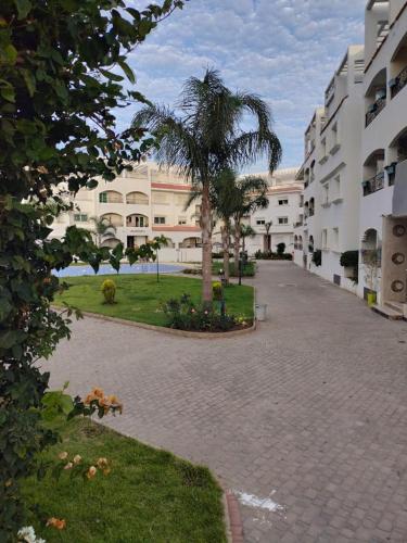 eine Palme mitten in einer Straße in der Unterkunft Puerta Del Mar Apartment complex in Tangier