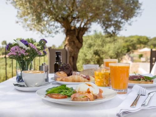 - une table avec des assiettes de nourriture et de boissons dans l'établissement Fincahotel Treurer - Olive Grove & Grand House - Adults Only, à Algaida