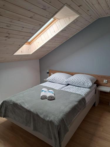 a bedroom with a bed with two slippers on it at Pokoje Iga in Władysławowo