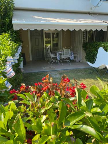 a house with a porch with a white canopy and red flowers at Raya Apartments Siviri Garden in Siviri