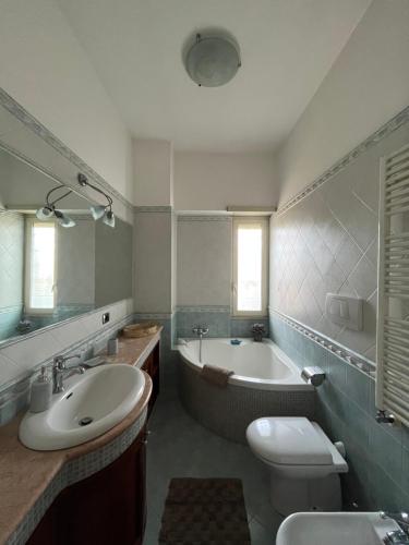 a bathroom with a tub and a sink and a toilet at Attico con terrazza in Via dei Traghetti in Lido di Ostia