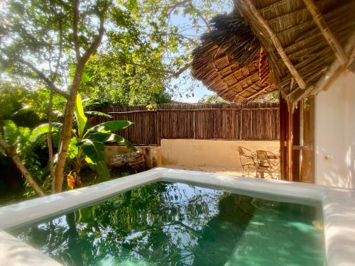 a swimming pool in the backyard of a house at Baobab Africa Lodge Zanzibar in Mtende