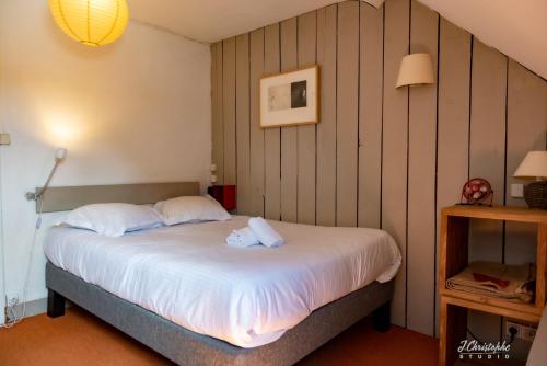 a bedroom with a bed with white sheets at Logis - Hotel & Restaurant La Corne d 'Abondance in Bourgthéroulde