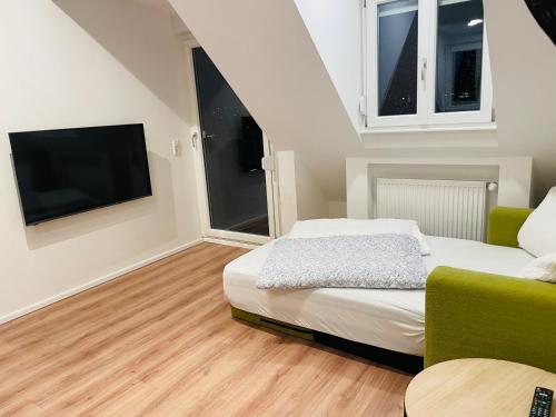 a bedroom with a bed and a tv and a couch at HD-Appartment mit Neckar- und Schlossblick in Heidelberg