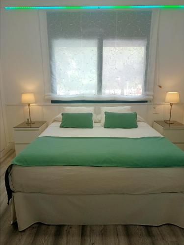 a bedroom with a bed with two pillows and a window at Ca la Carmeta in Cunit