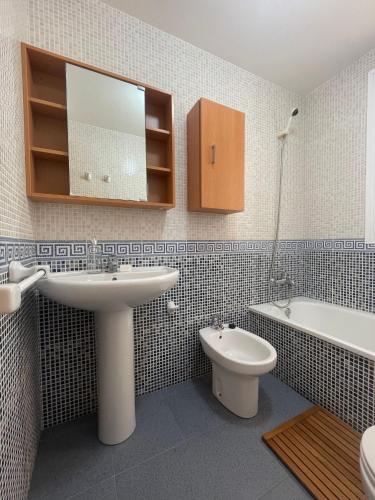 een badkamer met een wastafel, een toilet en een bad bij Piso con parking y piscina en Torrox costa in Torrox Costa