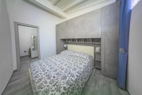 a bedroom with a bed with a blue and white comforter at Sun&Garden Flat in Cagliari