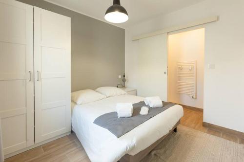 - une chambre avec un grand lit blanc et des serviettes dans l'établissement T2 plain-pied à 3 minutes du centre, à Castres