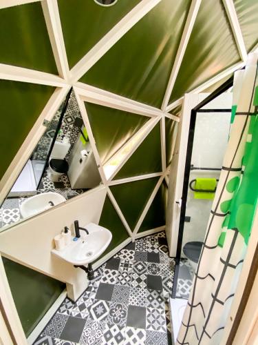 a bathroom with a green wall and a sink at Čiki Puki Glamping in Palanga