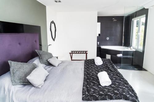 - une chambre avec un grand lit, un lavabo et une baignoire dans l'établissement Winery Hotel Boutique, à Algarrobo