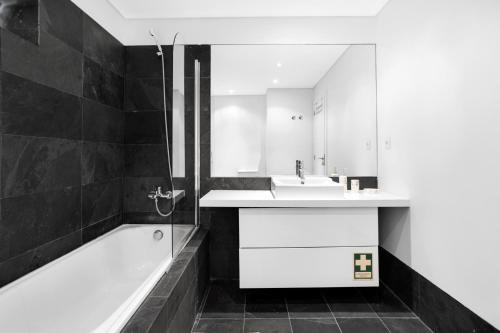 La salle de bains est pourvue d'une baignoire, d'un lavabo et d'une baignoire. dans l'établissement Janelas de Zimbra - Lovely Apartment with Pool and Sea View, à Sesimbra