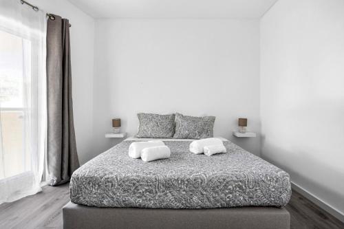 - une chambre blanche avec un grand lit et 2 oreillers dans l'établissement Janelas de Zimbra - Lovely Apartment with Pool and Sea View, à Sesimbra