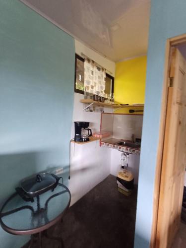a kitchen with a table and a stool in a room at House la Rosa third floor 5 in Quepos