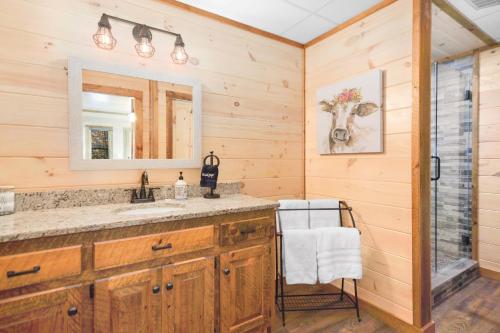 un baño con lavabo y espejo en Hooch Holler Hideaway, en Morganton