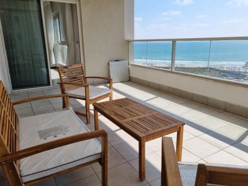 a balcony with two chairs and a table and a window at Ducks on the beach in ‘Akko