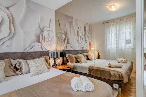 um quarto com 2 camas e toalhas em Spacious LUX BEACH Apartment em Split