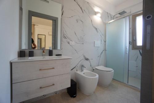 bagno con lavandino, servizi igienici e specchio di b&b Villa Grazia a Leverano