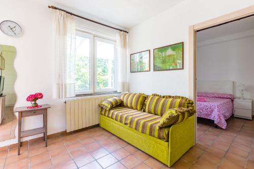 een woonkamer met een gele bank en een raam bij Le Castagne Apartments Ischia in Ischia