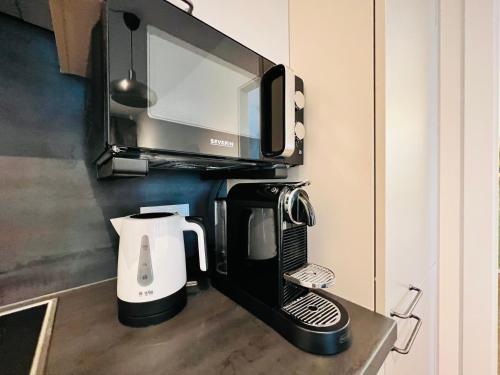 a microwave above a coffee maker on a kitchen counter at APSTAY Eggenberg I Self Check-in I Parking option in Graz