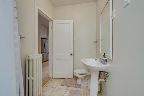 a white bathroom with a toilet and a sink at Minneapolis Vacation Rental - 1 Mi to Downtown! in Minneapolis