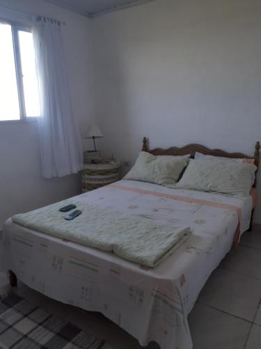 a large bed in a bedroom with a window at Pé na areia in Ilha Comprida