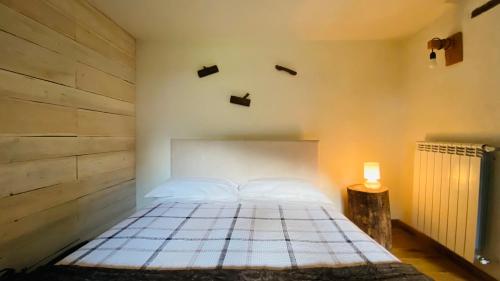 ein Schlafzimmer mit einem Bett und einer Lampe auf einem Tisch in der Unterkunft La casa di Tommy in Savoulx