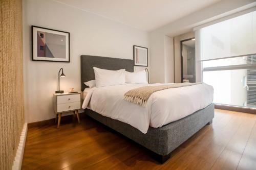 a bedroom with a large bed and a window at Las Mimosas by Wynwood House in Lima