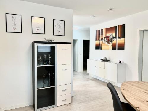 une salle à manger avec une armoire blanche et une table dans l'établissement Apartment Brochenzell - nahe Ravensburger Spieleland, à Meckenbeuren