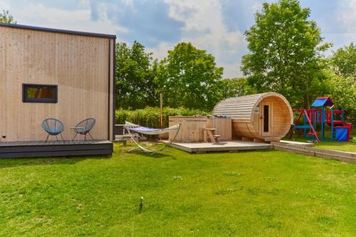 een achtertuin met een ronde schuur en een speeltuin bij Domki RWL in Rewal