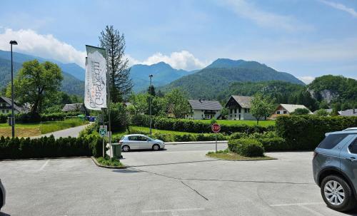 a car parked in a parking lot with mountains in the background at Hotel Gasperin Bohinj in Bohinj