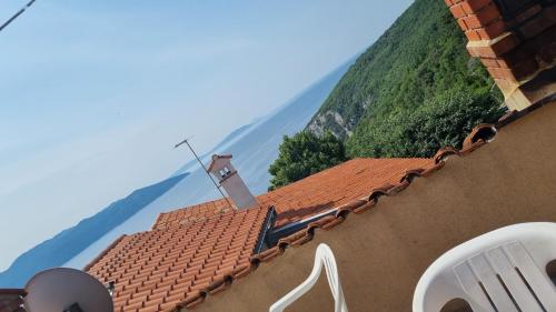 a view of a roof of a building with mountains in the background at Sobe Biserka i Mario Brseč in Brseč