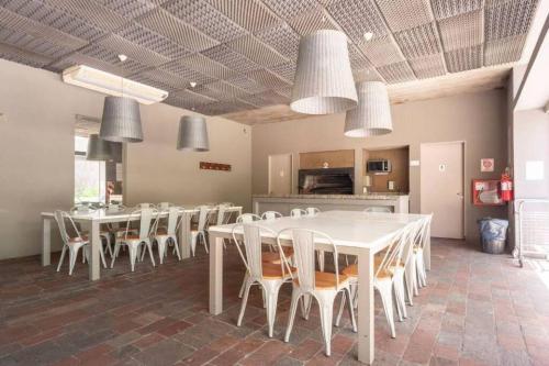 a large dining room with white tables and chairs at Tu Apart en Buenos Aires 11 in Buenos Aires