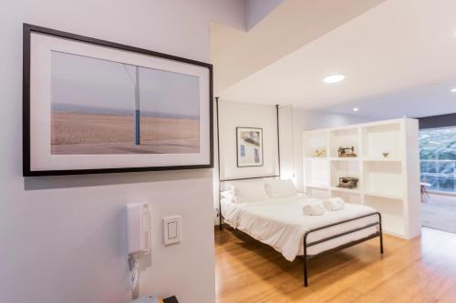a bedroom with a bed and a picture on the wall at Las Mimosas by Wynwood House in Lima