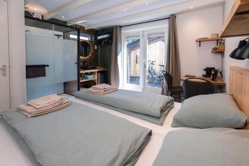 two beds in a room with a window at Bed & Bike Schoudieck in Den Burg