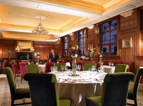 a man standing at a table in a restaurant at International Hotel Killarney in Killarney