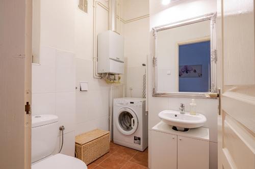 a white bathroom with a washing machine and a sink at Vintage Home next to Central Market Hall in Budapest