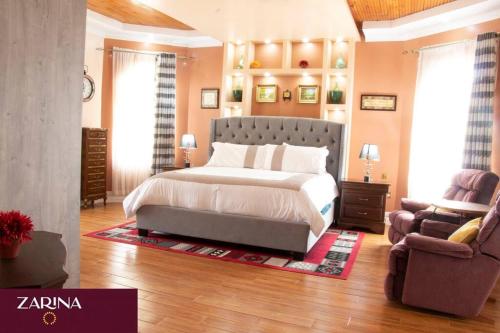 a bedroom with a large bed and a chair at LAIKIPIA WHITE HOUSE-NANYUKI in Timau